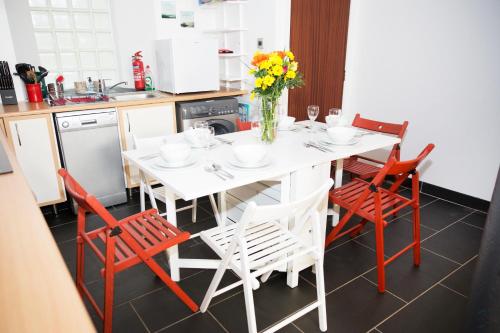 a kitchen with a white table and red chairs at The Neuk Anstruther Sleeps 6 Fantastic Location in Anstruther