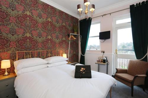 a bedroom with a white bed and a chair at The Bishop and The Bison in York