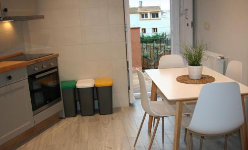 a kitchen with a table and a table and chairs at Ca l'Àvia Remei in Castelló d'Empúries