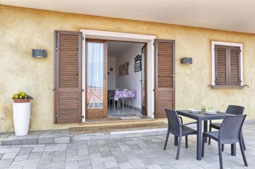 un patio con tavolo e sedie di fronte a un edificio di Monolocale Tre Mari a Capoliveri