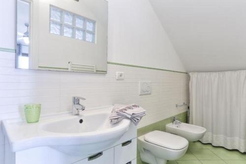 Baño blanco con lavabo y aseo en Monolocale Tre Mari, en Capoliveri