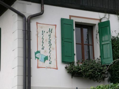 a building with green shutters and a window at Villa Margherita in Anduins