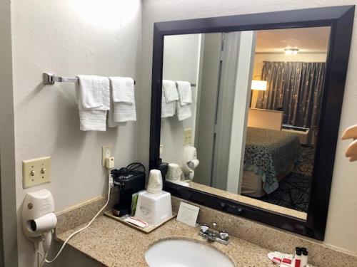 a hotel bathroom with a sink and a mirror at Days Inn by Wyndham Manning in Manning