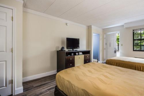 a hotel room with two beds and a tv at Quality Inn Hampton - Newport News in Hampton