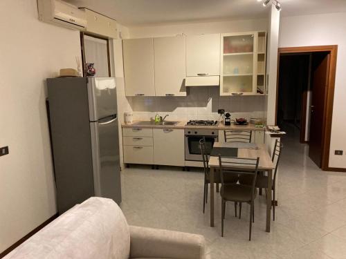 Il comprend une cuisine équipée d'un réfrigérateur, d'une table et de chaises. dans l'établissement la nostra casa..., à Novara