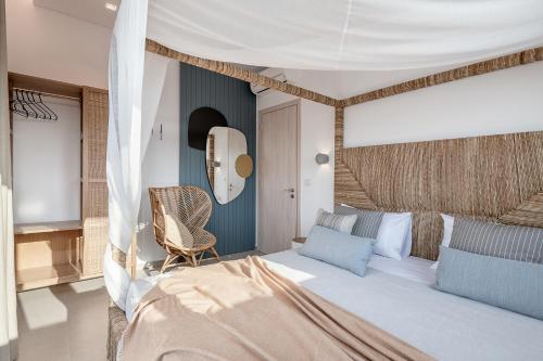 a bedroom with a bed and a chair at Anthos Villas - Chania in Tavronitis