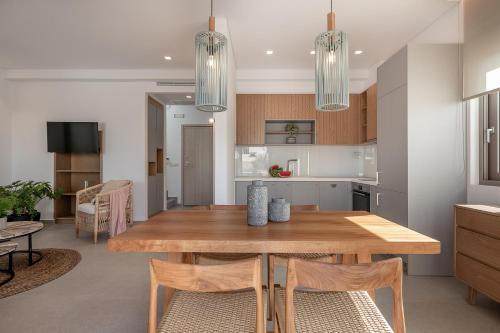 a kitchen and dining room with a wooden table and chairs at Anthos Villas - Chania in Tavronitis