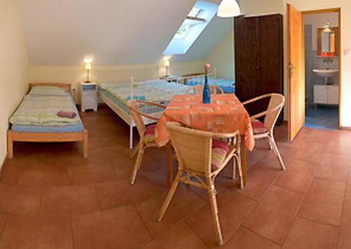 a dining room with a table and a bed at Jihočeský Statek in Dynín