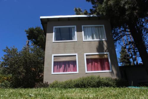 un edificio con cortinas rojas en las ventanas en San Benito de Palermo en San Carlos de Bariloche