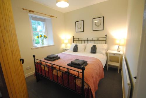 a bedroom with a bed with two towels on it at Mauldslie Hill Cottage in Gorebridge