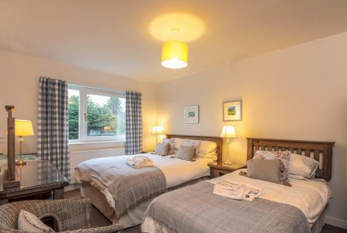 a bedroom with two beds and a window at Beachview Holiday Flat 2 in Lossiemouth