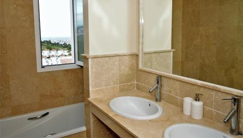 a bathroom with two sinks and a mirror and a tub at Pool- AirCon- Quiet&Peaceful- FamilyFriendly in Manilva