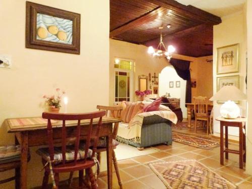 a living room with a table and a bedroom at Cosy 6 Person Cottage with Mountain View in Barrydale