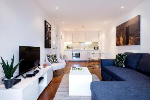 a living room with a couch and a tv at Luxury 2-Bed Flat parking near Tube and Emirates in London