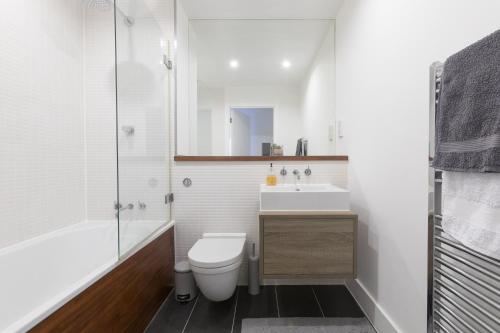 een badkamer met een toilet, een wastafel en een douche bij Luxury 2-Bed Flat parking and close to the tube in Londen