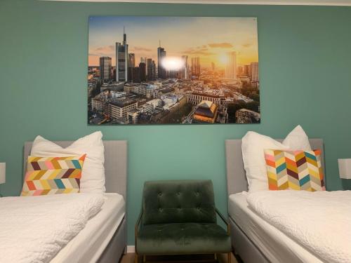 a room with two beds and a chair in it at ARGENTA Living 2 in Fulda