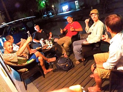 a group of people sitting on a deck at night at 4Bed Family Room Aosh ima Guesthouse Hooju Vacation STAY 13477v in Miyazaki