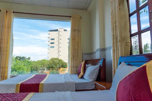 1 dormitorio con 2 camas y ventana grande en Nhat Lan Resort, en Phu Quoc