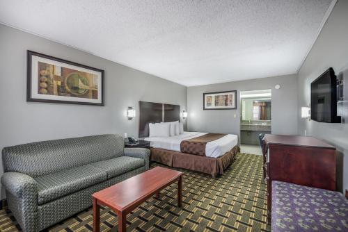 une chambre d'hôtel avec un lit et un canapé dans l'établissement Americas Best Value Inn Arkadelphia, à Arkadelphia