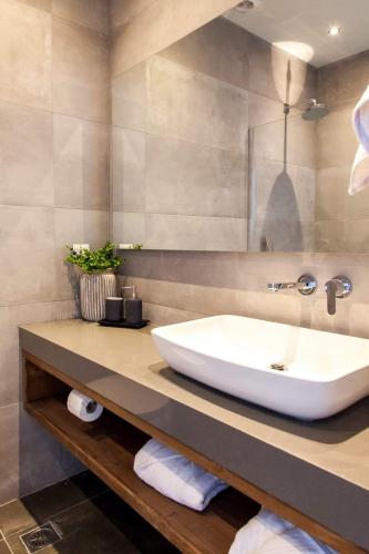 a bathroom with a white sink on a counter at Villa ECO LUXE in Sivota
