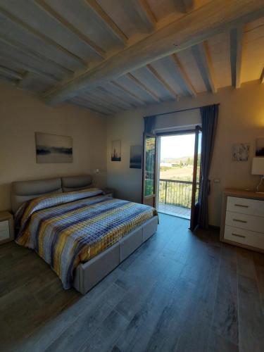 1 dormitorio con 1 cama y puerta corredera de cristal en Carlino Vacanze, en Gaiole in Chianti