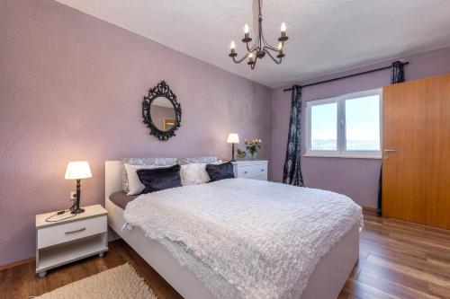 a bedroom with a white bed and a mirror at Apartman ELLA in Peračko Blato