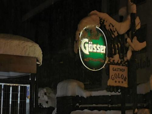 a sign for a gas station in the snow at Gasthof-Pension Golob in Kirchbach