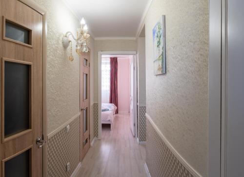 een hal met een kamer met een bed en een televisie bij 4х комнатные апартаменты in Pavlodar