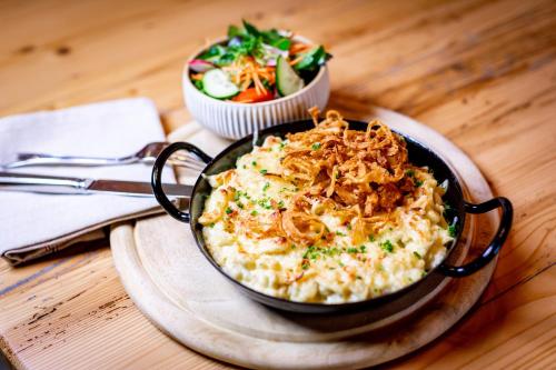 a pan of food on a table with a bowl of food at Landgasthof Hotel Gentner in Nürnberg