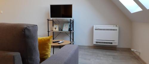 a living room with a couch and a television at Sky Blue Danube Apartment Ruse in Ruse