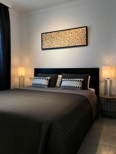 a bedroom with a large bed with two lamps at Residentie Montesol in Torrox
