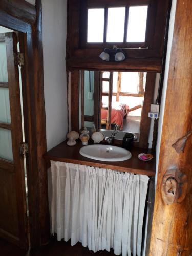 a bathroom with a sink and a mirror at Cabaña El Cóndor - Complejo El Taller in Potrerillos