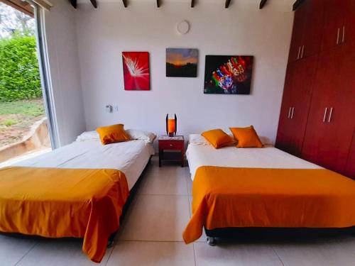 two beds sitting next to each other in a room at FINCA LUNADAR ANAPOIMA in Anapoima