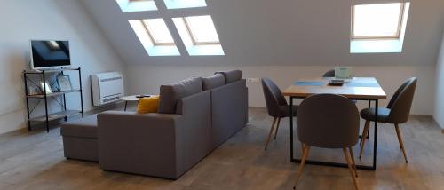 a living room with a couch and a table with chairs at Sky Blue Danube Apartment Ruse in Ruse