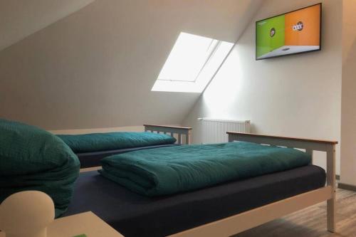 a room with two beds and a tv on the wall at EXKLUSIVE Ferienwohnung in Einbeck, 3 Schlafzimmer mit Balkon! in Einbeck