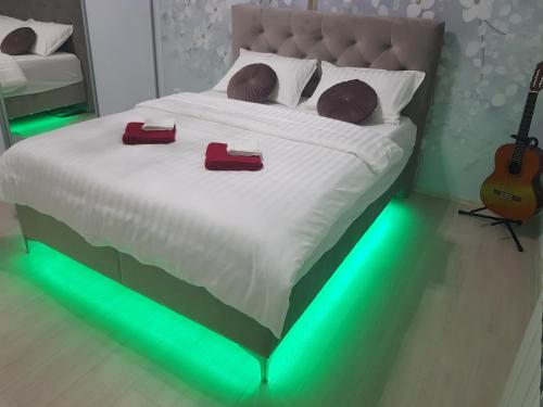 a bedroom with a bed with green lights on it at Apartman Akik 2 in Šabac