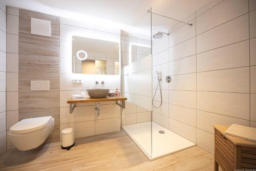 a bathroom with a toilet and a glass shower at Landhotel Zur Guten Einkehr in Bautzen