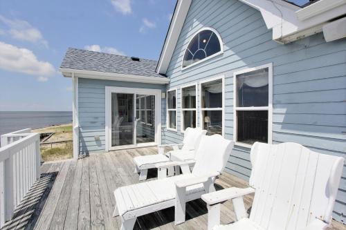 a blue house with white chairs on a deck at Devon's Landing #3-PA in Avon