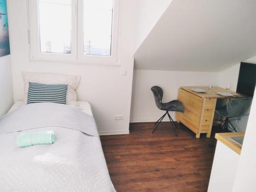 a small bedroom with a bed and a desk at Sroom Stuttgart Flughafen Messe in Leinfelden-Echterdingen