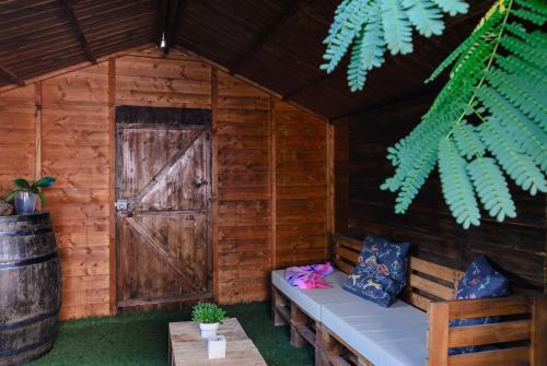 a wooden cabin with a door and a bench in it at Casa Doña Justa in Tegueste