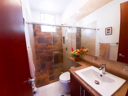 a bathroom with a shower and a sink and a toilet at FINCA LUNADAR ANAPOIMA in Anapoima