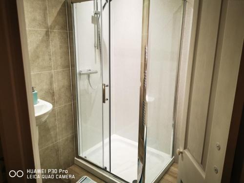 een douche met een glazen deur in de badkamer bij oddfellowsbandb in Blythe