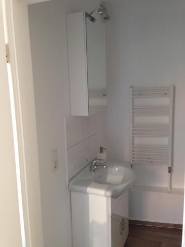 a white bathroom with a sink and a mirror at Ferienhaus Brücke in Quedlinburg
