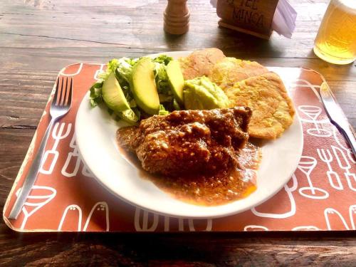 a plate of food with meat and vegetables on a table at Hotel Minca - La Casona in Minca