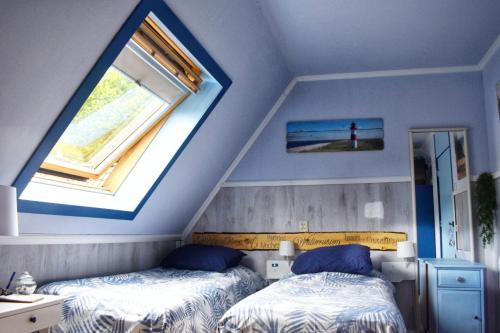 two beds in a room with two windows at Duinberk B&B hotel en Brasserie in Schoorl