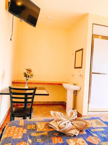 a room with a table and a chair and a sink at Hotel Sociedad y Maristas in Tecolutla