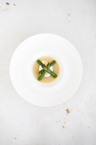 a white plate with a green object in a bowl at Residenza San Vito in Calamandrana