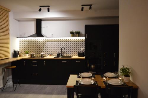 a kitchen with a table with chairs and a sink at Apartament M&I in Koszalin