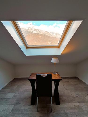 an attic room with a table with a skylight at Walensee House & Apartments in Unterterzen