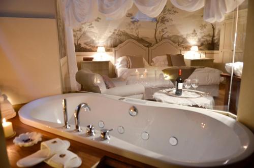 a bath tub in a room with a bedroom at La Corte Di Ambra in Cortona